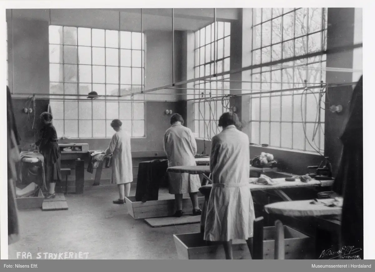 Kvinner på arbeid i strykeriet ved Wilhelm Kahrs Kemisk Renseri & Farveri, Bergen.