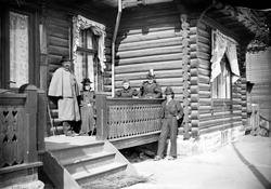 Gruppebilde på veranda, tømrahus, tre kvinner, to menn