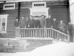 Menn foran en bygning