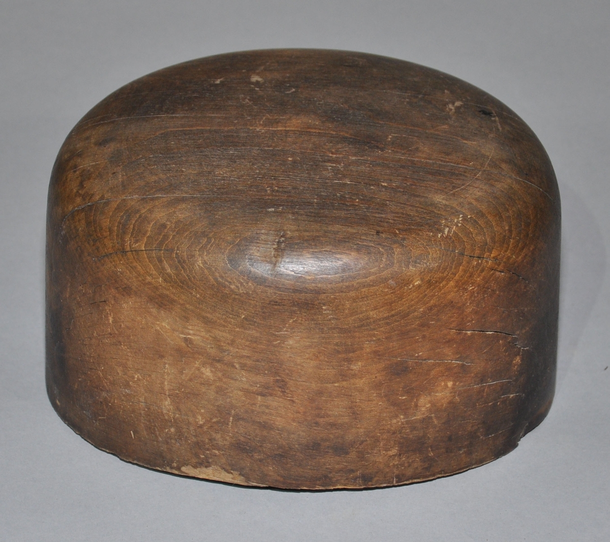 Hatteblokk skåret ut av ett trestykke, har en sylinderform hvor toppen er avrundet.
