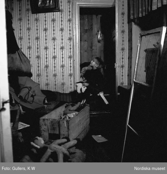 En liten pojke gungar på sin gunghäst i en trång och sliten lägenhet i Gamla stan, Stockholm.