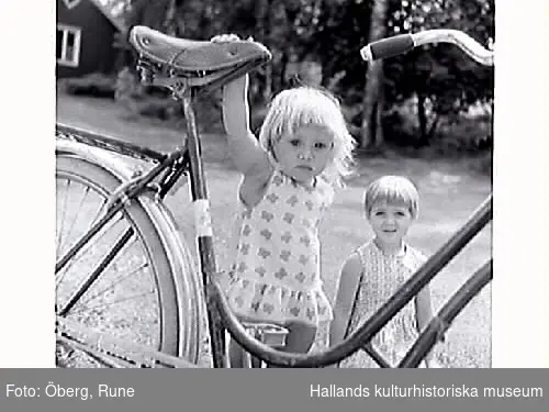 Flickorna (kusinerna) Ingmarie (i förgrunden) och Åsa vid farmors cykel.
