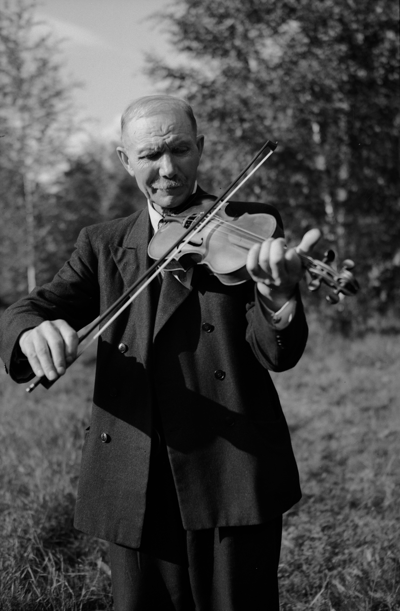 Spelman med fiol vid spelmanstävling i Granebergsparken, Sunnersta, Uppsala augusti 1945
