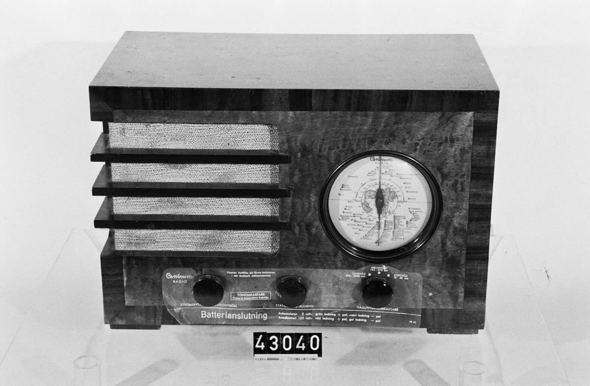 Nätansluten radiomottagare med cirkulär skala, med anvisningar på skiva av celluloid bakom rattarna.