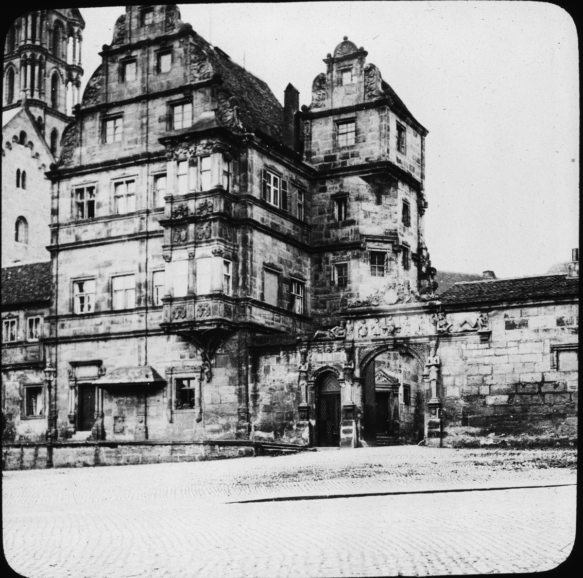 Skioptikonbild med motiv av Alte Hofhaltung, gamla domstolen i Bamberg, främre fasad på Cathedral Square.
Bilden har förvarats i kartong märkt: Resan 1906. Bamberg 8.