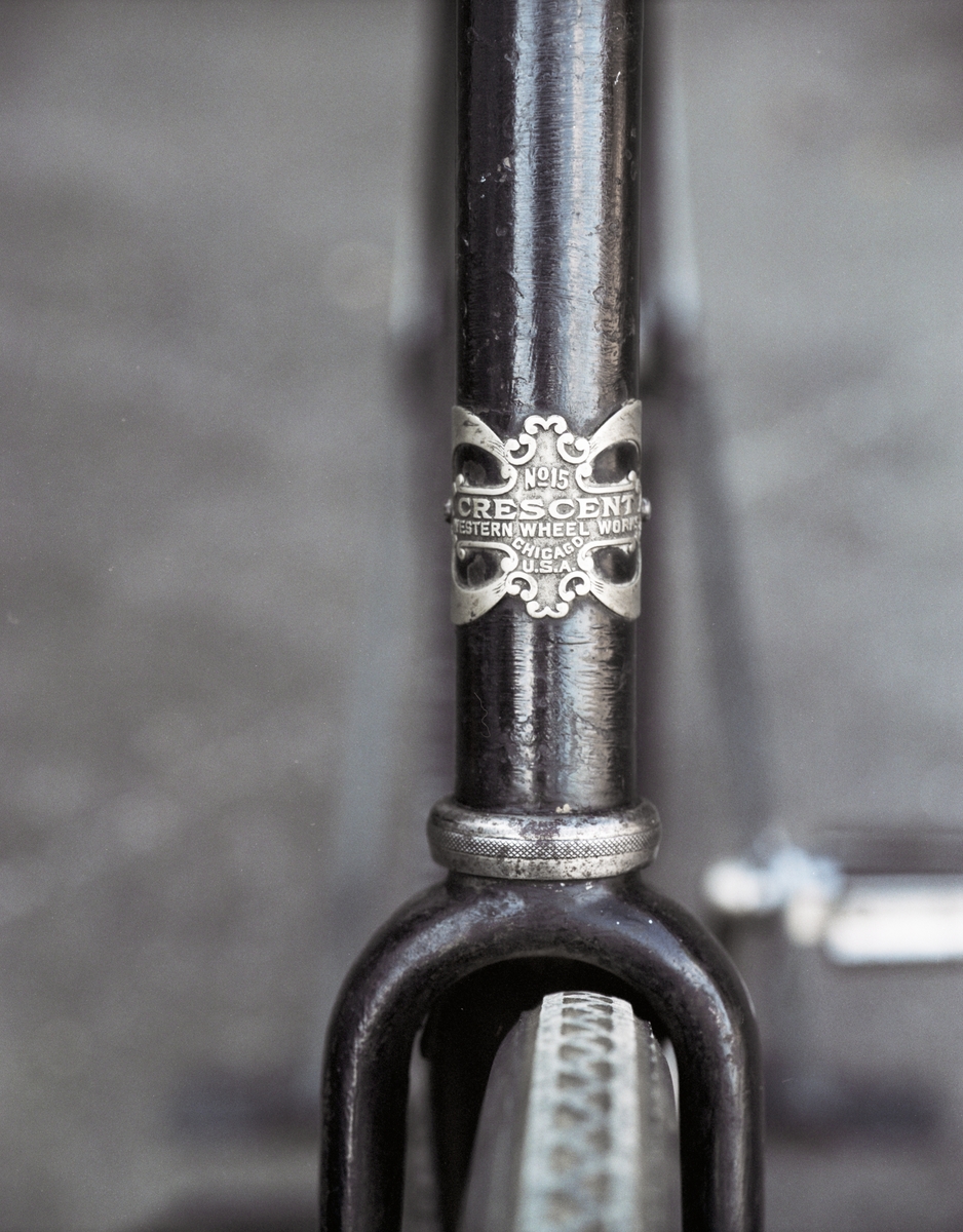 Cykel utrustad med blockkedja, med stänklapp av läder. Nummerskylt 184011. Cykellås: Reina. Skärmarna randade med guld. Ringklocka på styret. Mycket troligen nytt, t.ex. skärmar, styre, sadel och bakhjul.