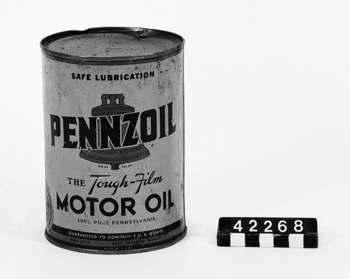 Tom plåtburk, märkt: "Pennzoil The Tough-Film Motoroil 100% Pure Pennsylvania Safe Lubrication Garanteed to contain 1 US Quart, 0,9463 liter, 0,8327 Imperial Quart Made in USA. Filled and seald by The Penzoil Companyrefineries: Oil City, PA Member Penn. Grade Crude Oil AssÃ¯n. Permit No 2".