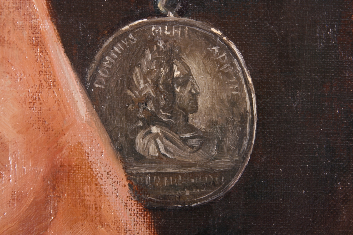 Portrett av Peter Wessel Tordenskiold. Avbildet i mørk rustning med rødlig kappe over høyre skulder. Medalje på brystet.