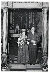 Brudepar på vei ned fra alteret. Kvinnen er iført bunad og m