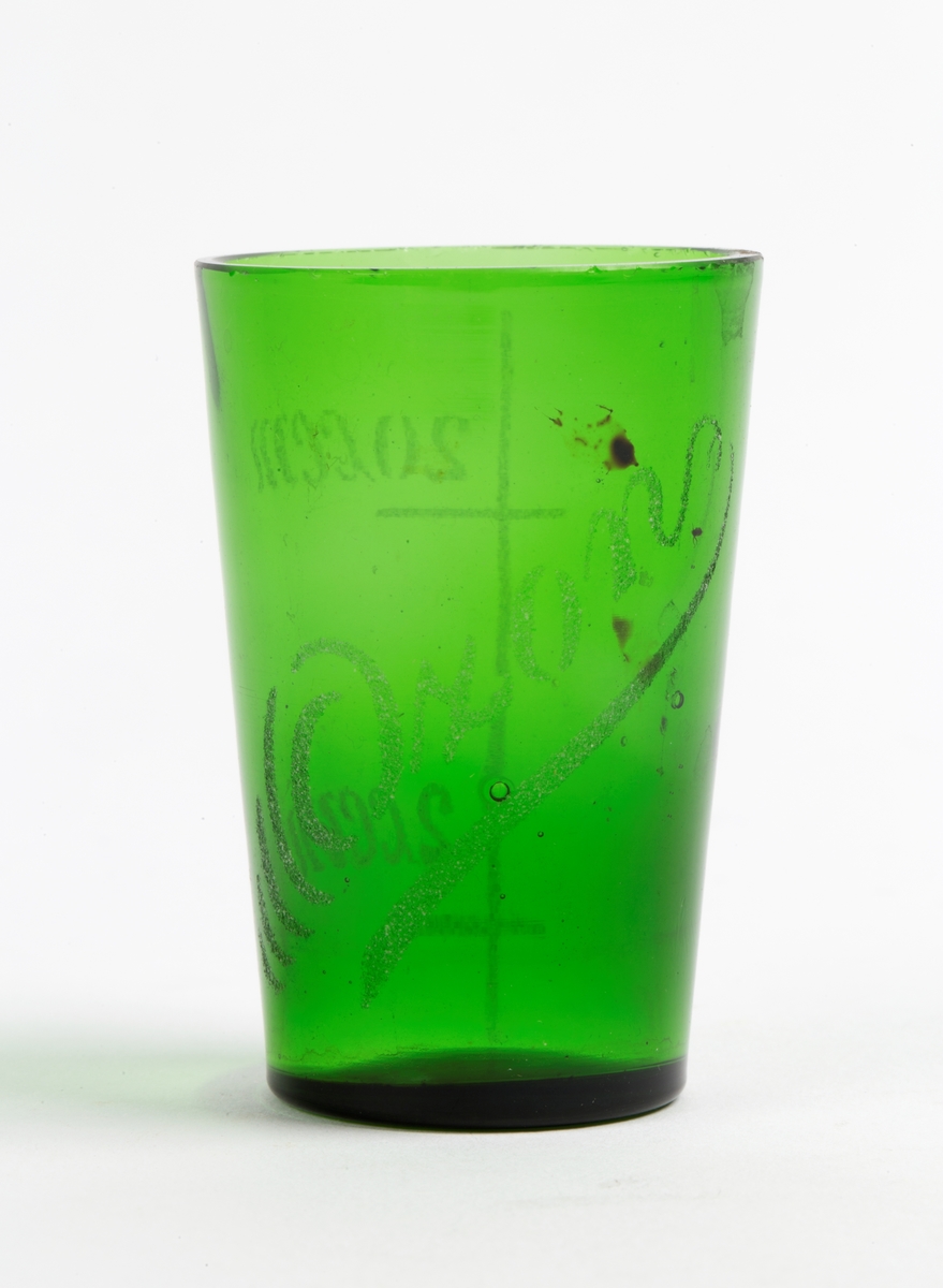 Måleglass med avmerning til 0,2 og 20 ml.
Logo på baksiden.