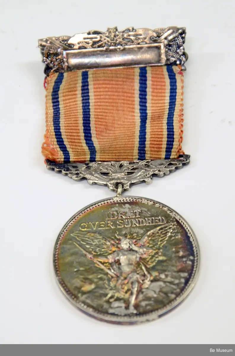 Medalje (ant. deltakermedalje) med innskrift:
"IDRÆT GIVER SUNDHED" (på framsiden)
"KONGSBERG IDRETSFORENING" (på baksiden)
Bånd i det norske flaggets farger - sterkt falmet.