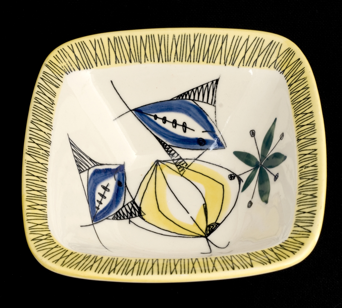 Dekorert med motiv av gul sitron, grønne blader og blå fisker. Kranset med bambusmotiv av svarte streker på gul bakgrunn.