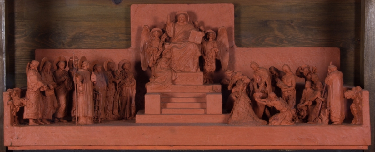Jesus sittande i centrum på en upphöjd tron med höjd vänsterarm, Majestas Domini. Upp till tronen leder en trappa. I den högra handen håller han en bok. På var sida om honom en ängel och vid hans fötter en sittande kvinna. Till vänster om tronen stående figurer med glorior. Till höger delvis stående, delvis knäböjande figurer, totalt 23 figurer.
