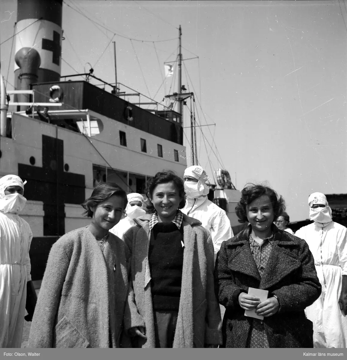 Kvinnliga flyktingar från Bergen-Belsen anländer till Kalmar med skeppet Prins Carl. Observera mottagarnas andningsskydd! Många patienter hade tyfus och TBC.