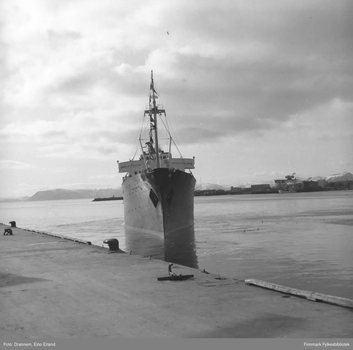 Et skip på vei inn mot Dampskipskaia i Hammerfest. Skipet ligner på MS Vesteraalens rederilogo på hver side av baugen.  Dette må derfor være M/S Vesterålen. På dette bildet ser man Fuglenesodden i bakgrunnen.