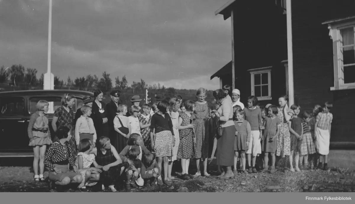 Sanitetsforenings feriekoloni i Repparfjord, fotografert 20.8.1936. Bak bildet en tekst: " Bananene deles ut".