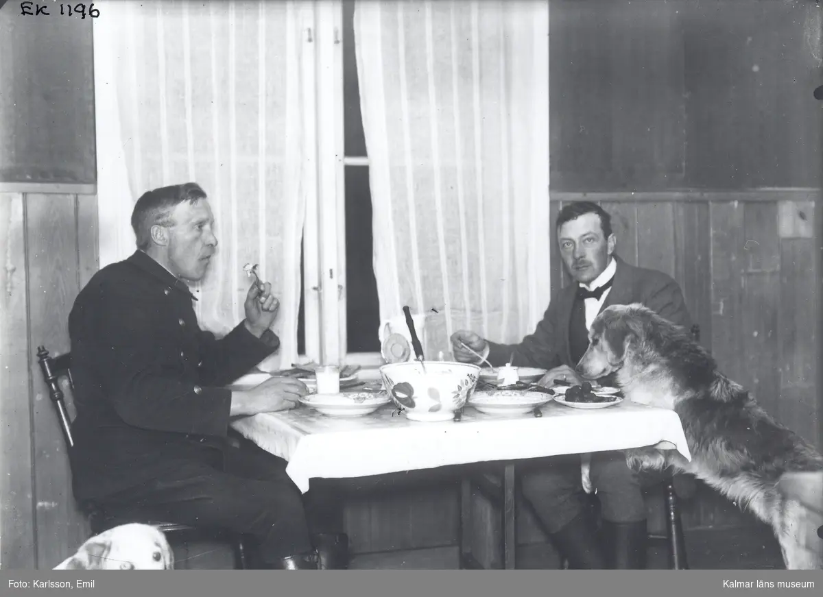Måltid vid köksbordet i Josefinelund. Mannen till höger: skogvaktare Ernst Dahlqvist, Misterhults gård. Mannen till vänster okänd, troligen någon skogstjänsteman.