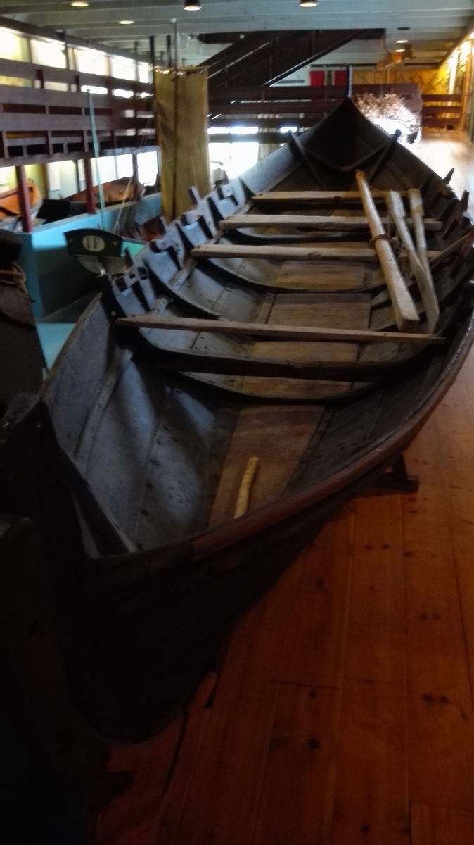 1 båt fra Vetlefjorden

Gammel 4 kjeips båt (otring) fra Vetlefjorden. Båten der er over 100 år gammel er bygget på Slinde av båtbygger Ole Rise fra Leikanger. Den har vært brukt som förslebåt for kreaturer, löv, höi, ved ute i Vetlefjorden samt i senere tid som ekspedisjonsbåt til dampskibene. Har nu i mange år stått i nöst og er noget skröpelig. Længde 7,90 m, bredde 2,08 m. Tjærebredd. Seil og mast med tekkelage(?) mangler. Har defekt ror og tre tiljer, ökset av stokk og tykkest i enderne. Den ene toft har innskåret årstallet 1912. Fire bord i höiden. Plitten og tiljen mangler. Har foran "kodlar" (til fortöiing) på begge sider.
Båtens siste eier var gårdbruker Per Feten og er båten gave fra dennes sön.

Gave fra gårdbruker Anders P. Feten, Vetlefjorden.