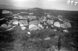 Bilde av en gammel gravrøys på Valen, Edøy, med et gravkamme