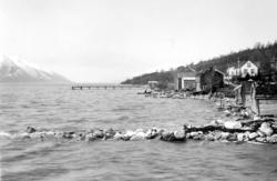 Fotografi av naust og hus ved fjorden i Eidsvågen, Møre og R