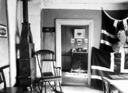 Interiørfoto fra en stue,hvor vi ser to store norske flagg r