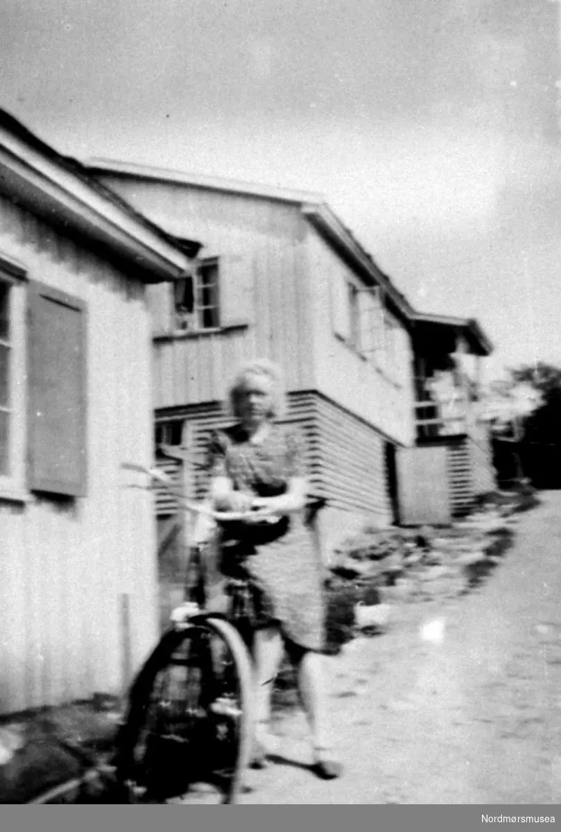 Jente på sykkel, brakke, serie, Kristiansund ca 1947. Fra Nordmøre Museum sin fotosamling.