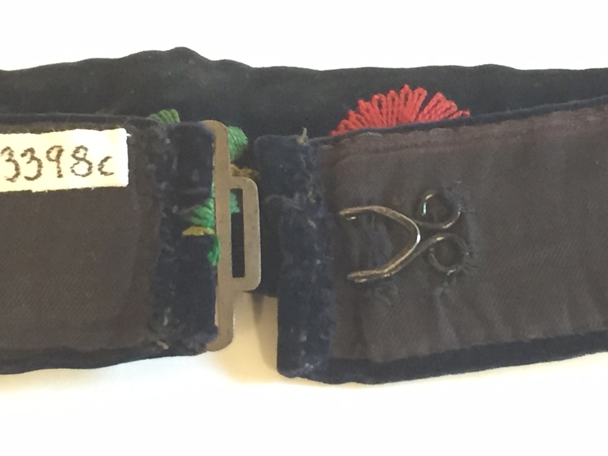 Lue, bryststykke/bringeduk og belte (C) til hardangerbunad, forkle (E) og skjorte (D) med hardangersømdetaljer.