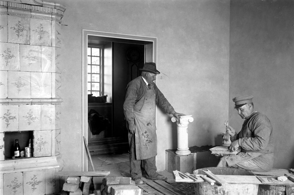 Kakelugnar monteras år 1929. Mannen till höger är en av bröderna Samuelsson vilka var kakelugnsmakare vid AB Frans Elinder.