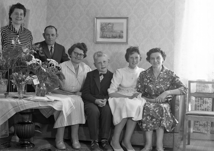 Foto av en ung kvinna i vit konfirmationsklänning, tillsammans med sin familj.
De sitter i ett vardagsrum, vid ett bord med blommor på.
Familjefoto 1959.
Födelsedag – konfirmation. Forsdala, Gård, Hjortsberga.
F.v. Hildur Zandin, f. Johansson, (1901–1986), jubilaren Lennart Nilsson 50 år, (f. 5 juni 1909 – 1972). Hustru Margit, f. Johansson, (1912–1995), barnen Mats-Ola Nilsson. (1949- ). Christina Nilsson, (1944-2014), Svea Johansson, f. i Moheda, (1902-1989). Hildur och Svea var systrar till Margit.