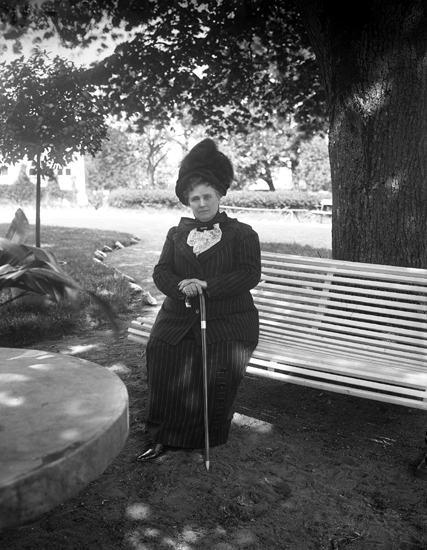 Christina Nilsson på sin födelsedag, sittande på en parkbänk i en park.