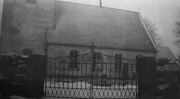 Foto på en kyrka med närbild på grinden utanför.