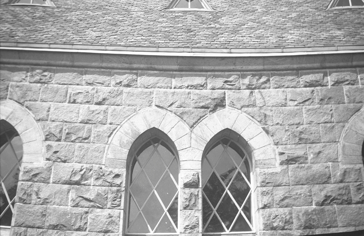 Närbild på två fönster.
Nuvarande stenkyrka i nygotisk stil uppfördes 1899 efter ritningar av arkitekterna Gustaf Petterson och Sven Gratz.