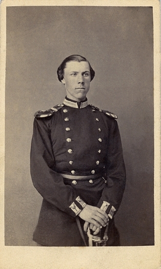 Porträtt (knäbild, halvprofil) av en ung man i militäruniform med epåletter m.m.
 
David Fabian Gustaf Adolf Ohlsson, underlöjtnant vid Jönköpings regemente I 12, född 23 september 1845 i Linneryd, död 5 augusti 1931 i Gränna. 
Gustaf Ohlson blev underlöjtnant vid Jönköpings regemente 1865, löjtnant 1869 och kapten 1885. Han blev major i armén och fick 1896 avsked med tillstånd att såsom kapten kvarstå i regementets reserv.
Han var uppfinnare av olletröjan. Han föreslog att soldaternas vintertida utrustning skulle kompletteras med en stickad grov ylletröja med långa ärmar. Ollen, som plagget snabbt kom att kallas (förmodligen kallades även kapten Ohlson för Olle), skulle heller inte ha knäppning (utom möjligtvis över ena axeln) utan skulle dras över huvudet. 
Gustaf Ohlson var från 1876 gift med Helena Malvina Frick (1847–1933). Han är tillsammans med hustrun begravd på Gränna kyrkogård.

Jfr familjebild, Pf738.
Källa: Bl a Folkräkning, Säby fs 1890, SVAR.