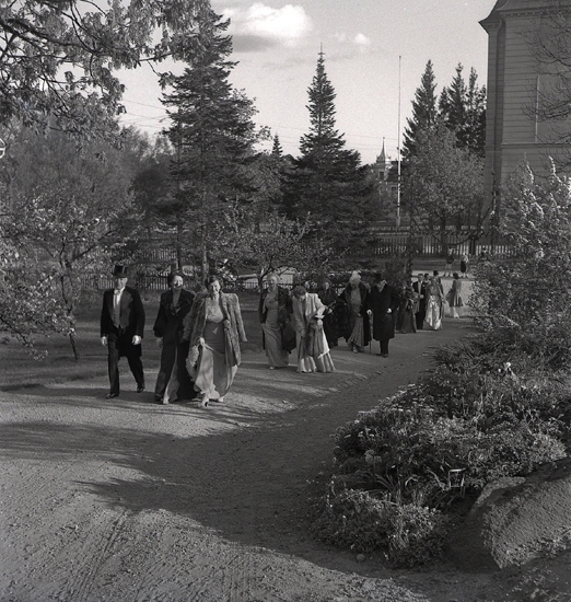 Doktorinnan Tegner, 19/5 1945. Bröllopsgäster på väg uppför en bred trädgårdsgång. I bakgrunden skymtar Växjö Flickskola.