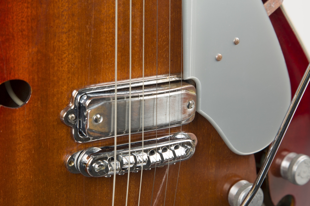 Elektrisk gitar med hul kropp ("hollow body") og finish i kirsebær. To humbucker-pickups med individuelle volum- og tonekontroller. Pickupvelger og vibratoarm.