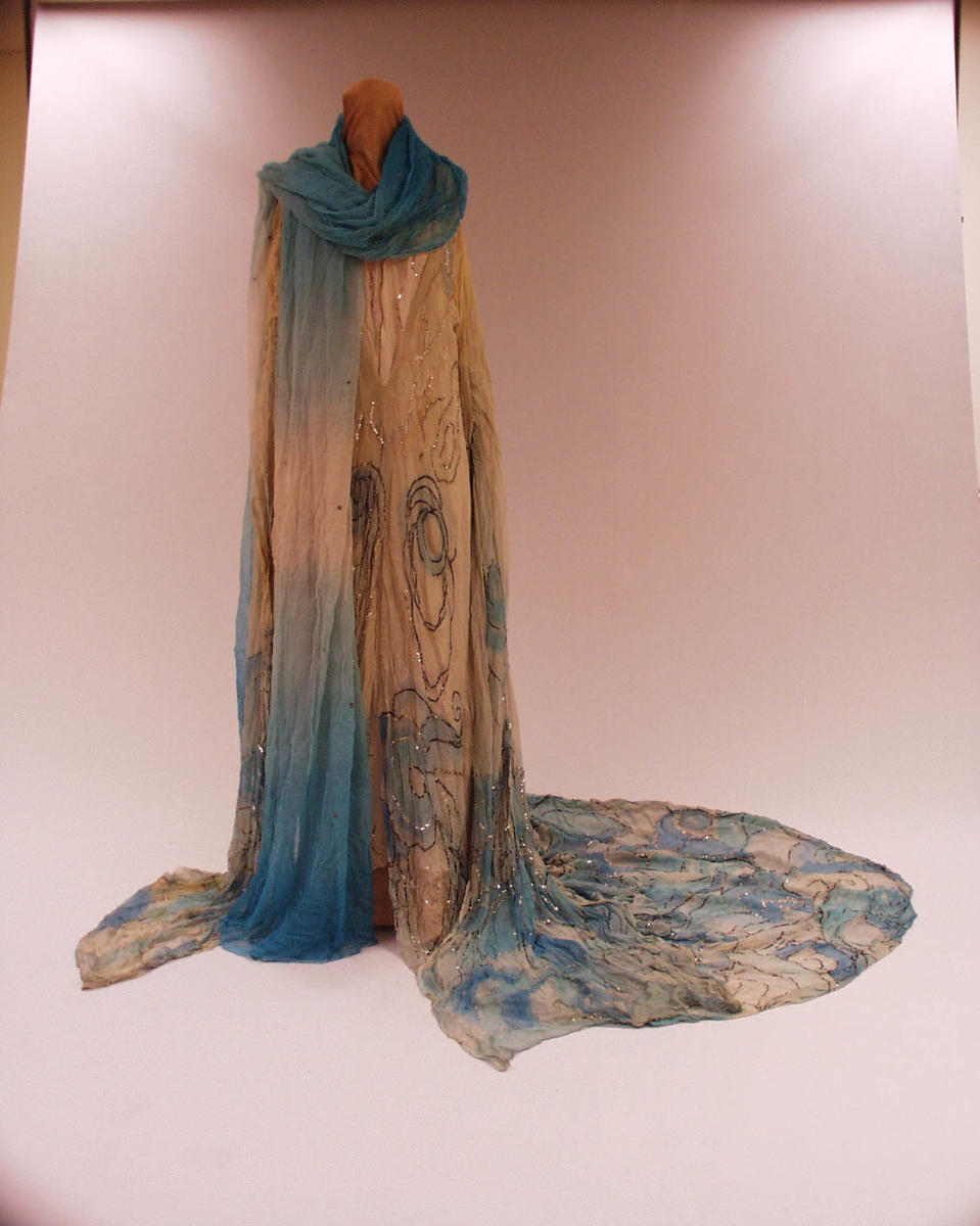 Kostyme Kirsten Flagstad. Fargerikt kostyme. En kjole med sjal og langt slep.