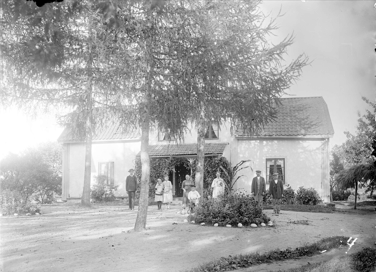 Grupp framför bostadshus, Uppland 1917