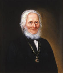 Portrett av Arnoldus v. W. S. Koren. Mørk drakt, medaljong (eller klokke?) i kjede rundt halsen. Foto/Photo