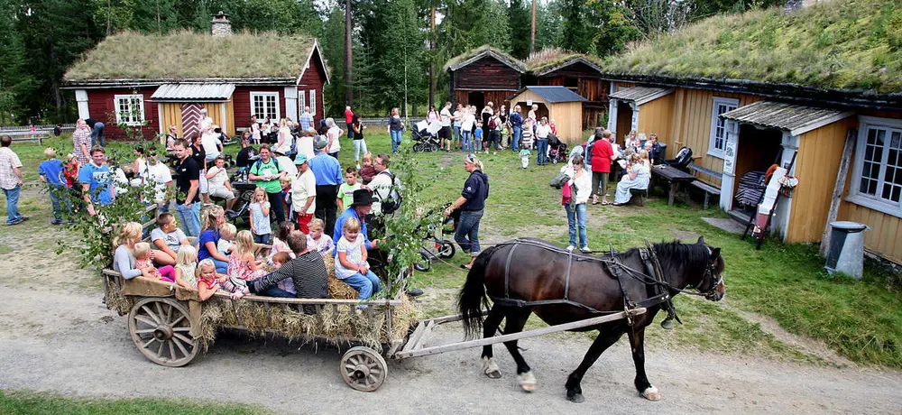 Folk på Elverumstunet, Glomdalsmuseet under et arrangement. I forgrunnen er det en hest og i bakgrunnen er det flere mennesker.