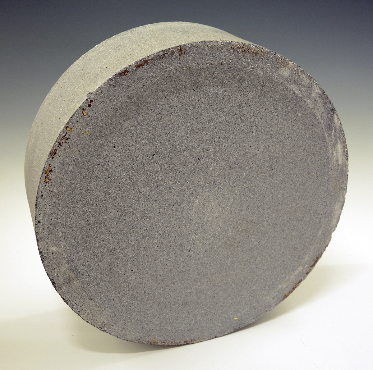 Rund kapsel i ildfast stein med syv porselenskopper på bumser/styringer (Merket A-G).