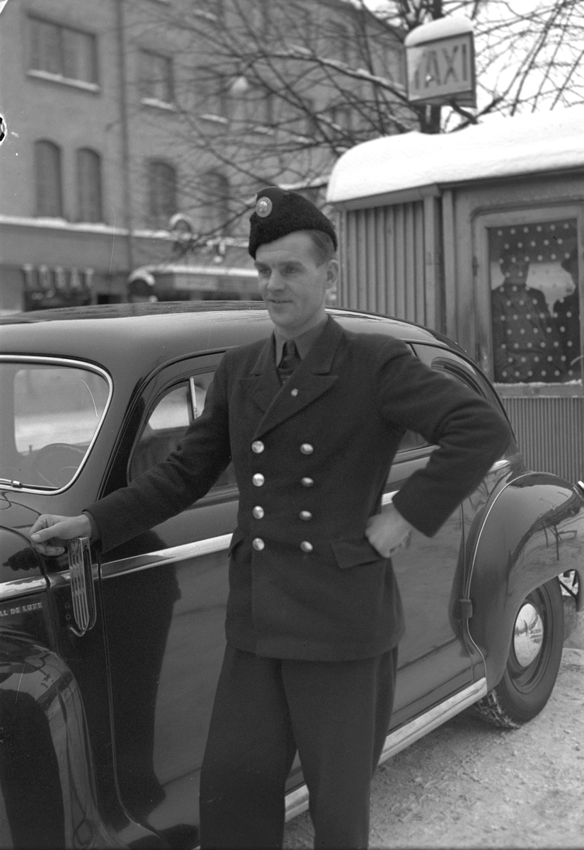 Taxichaufför Stråhle. 14 januari 1949. Reportage för Arbetarbladet. Bilden är tagen på Stortorget, inte Centralplan, med biografen Roxy i bakgrunden.