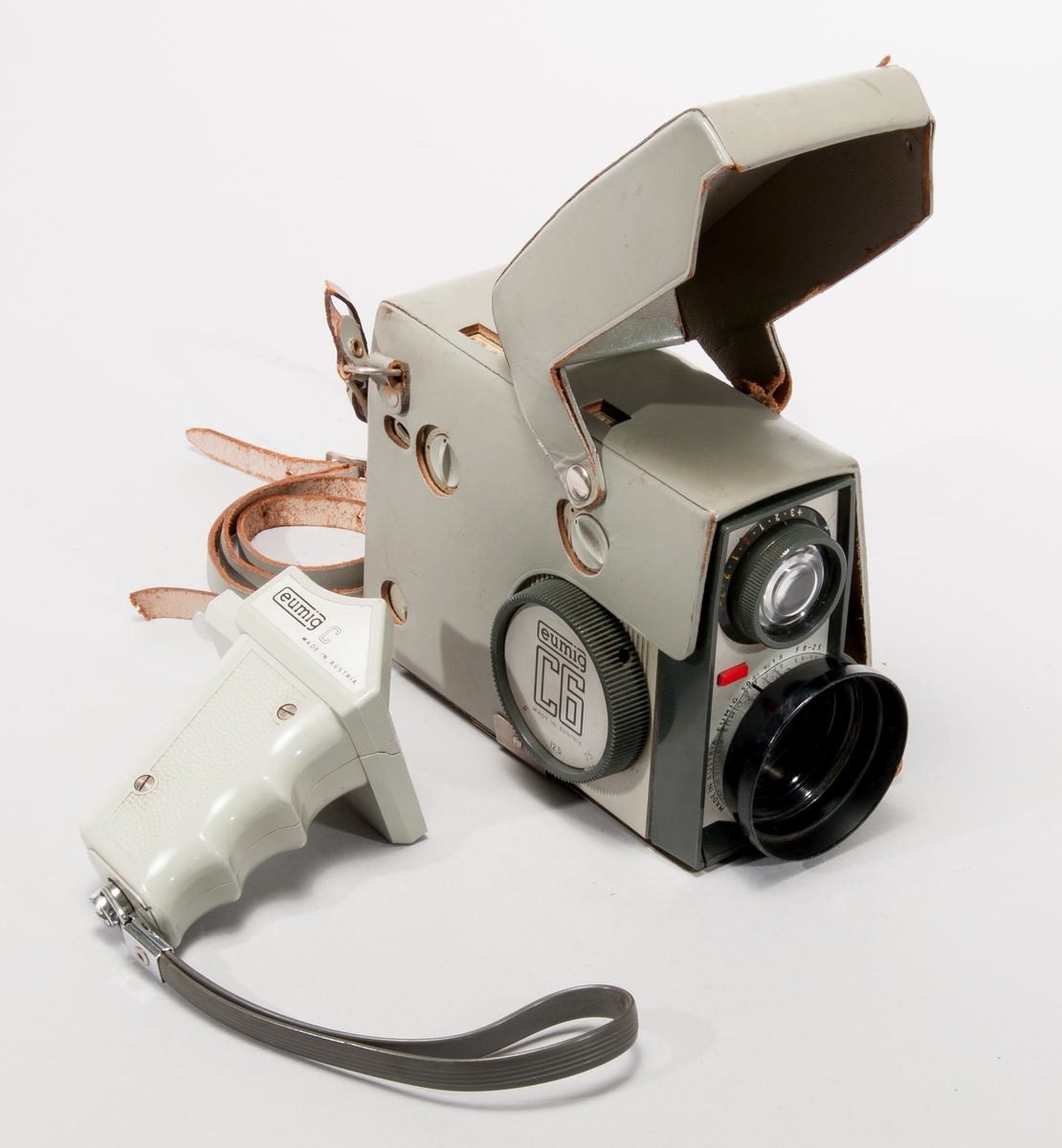 Filmkamera Eumig typ C6, med zoom mellan 6/12,5/25 mm, som kan motorstyras via tillhörande handgrepp Eumig C.
Objektiv Eumig 504, 1:1,8 F=8-25

Med grönt läderhölje.