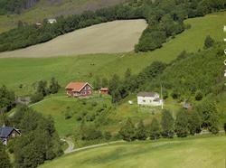 Kulturlandskap.  Ett brunt og ett hvitt bolighus med hager. 