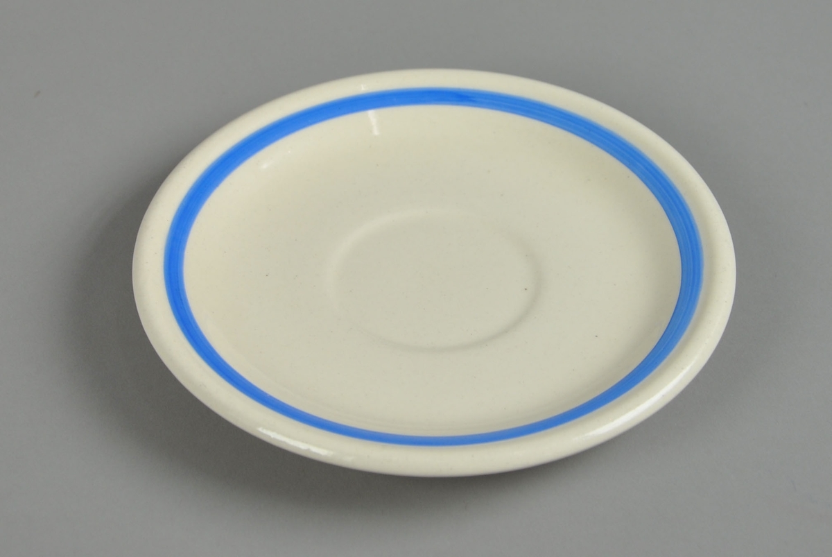 Hvit asjett av glassert keramikk. Asjetten har en blåmalt stripe innenfor kanten.