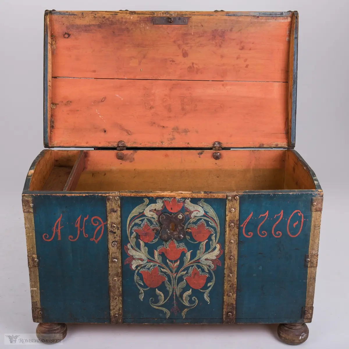 Rosemaling på blå bunn.  Det midtre feltet er dekorert med symetrisk rosemaling på blå bunn . I de to andre feltene på fronten er malt med initialene.