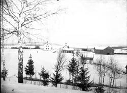 Vinterlandskap. I forgrunnen trolig gården Berg i Østre Tote