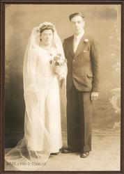 Brudepar. Hun i brudekjole, golvlangt slør og brudebukett, h