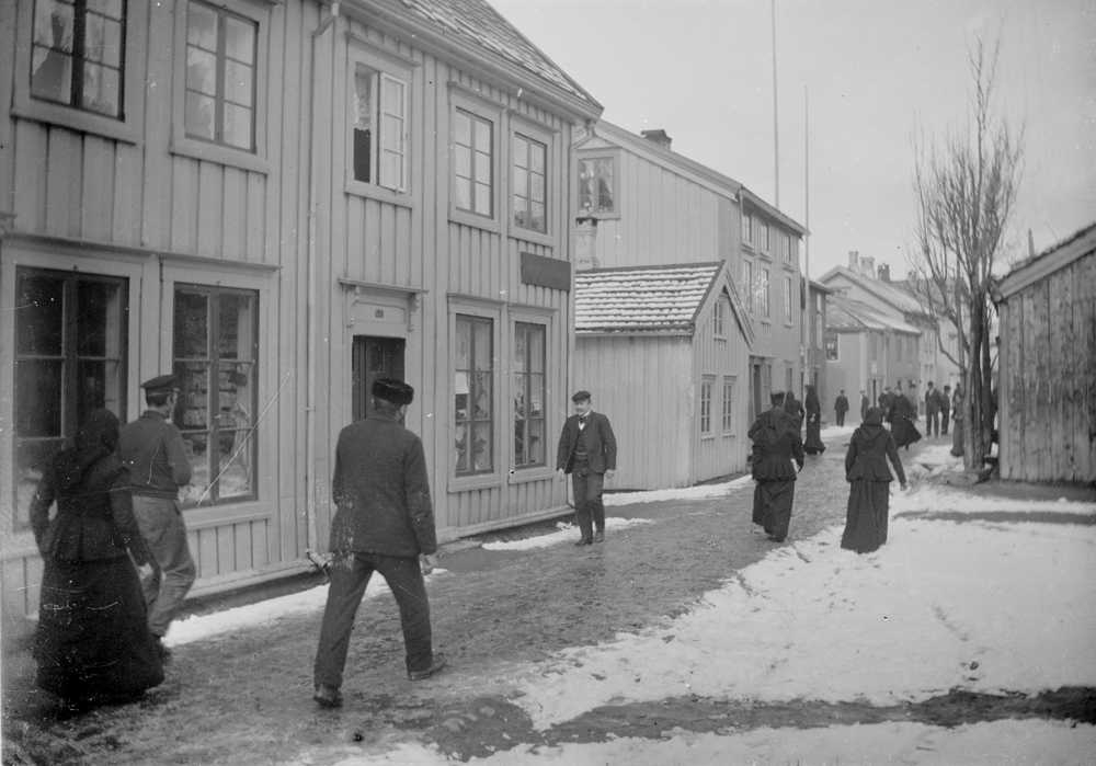Sjøgata sett nordover, det lille huset til venstre er "Lensmannsbua". Mye folk i gata.
