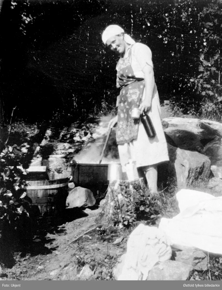 Skylling av klesvask i Rømsjøen i Rømskog. Kvinnen er G. Bergli, ca. 1928.