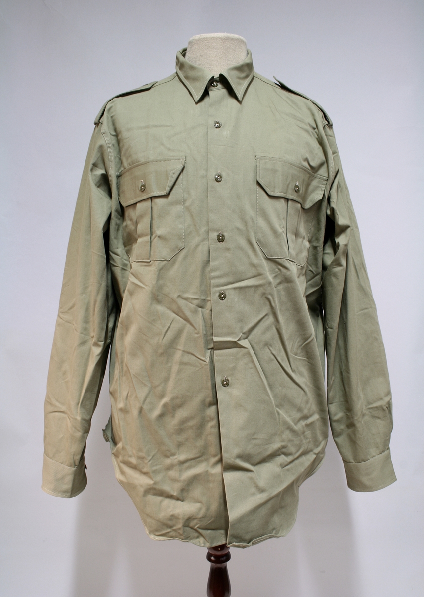 Battleuniform med bukse, skjorte, slips, bandolær. 

Kortet er tidligere utstilling og ikke en del av uniformen.
